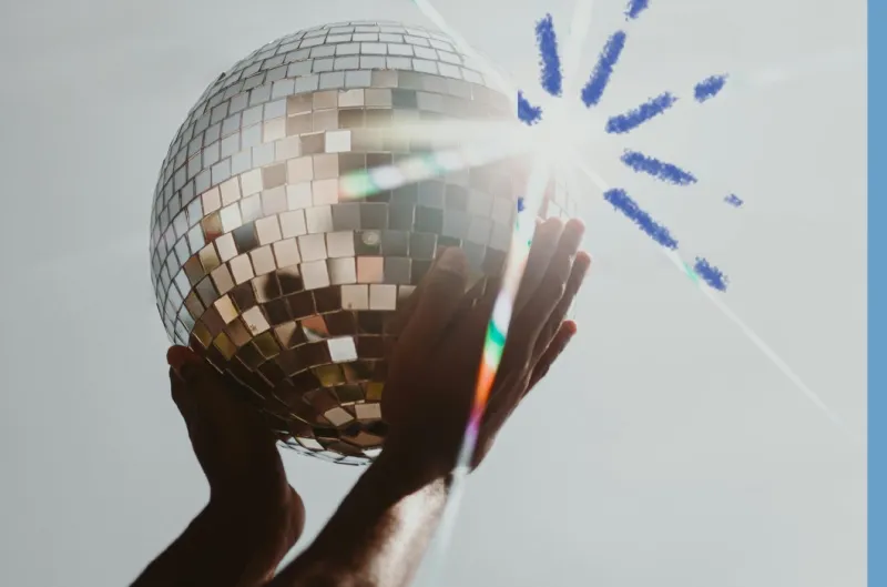 A mirror ball held up to the light at an evening event
