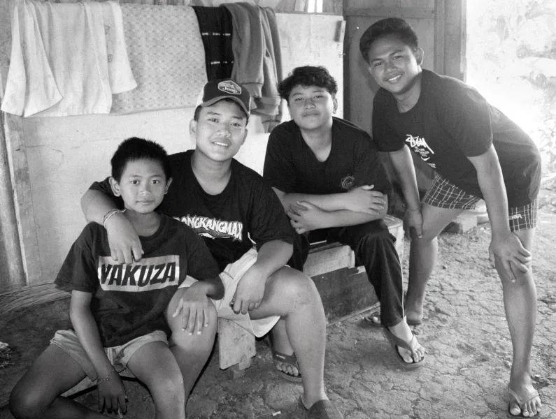 Four young students smiling together at home.