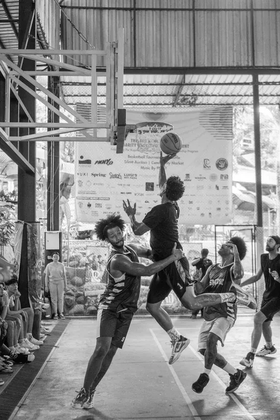 A contested layup under the basket during a tournament game