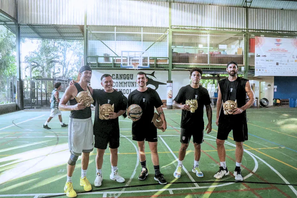 Finalists holding carved masks and trophies after the tournament