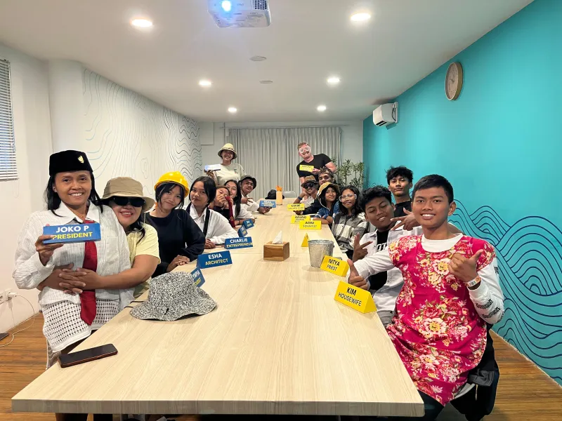 Scholarship students smiling around a table during a group workshop game.